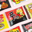 Colorful packaging of a ramen-shaped eraser with cute cartoon designs on a light pink background