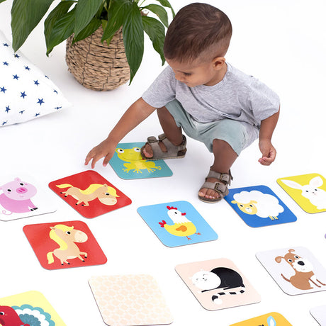 Toddler playing with colorful animal cards in the Suuuper Size Memory Game, designed for early learning and fun.