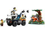 Toy off-road truck with rugged tires and movable camera alongside jungle scene with tiger and tree figures