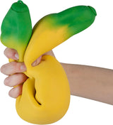 Hand squeezing a soft, stretchy jumbo banana toy slowly rising and bending in yellow and green colors