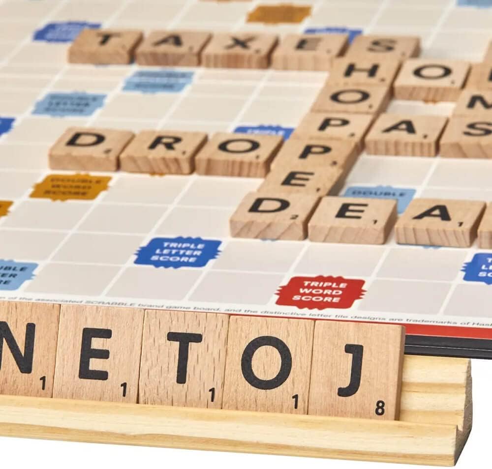 Scrabble board game with wooden letter tiles forming words on a colorful game board