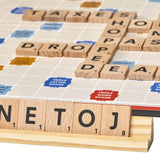 Scrabble board game with wooden letter tiles forming words on a colorful game board