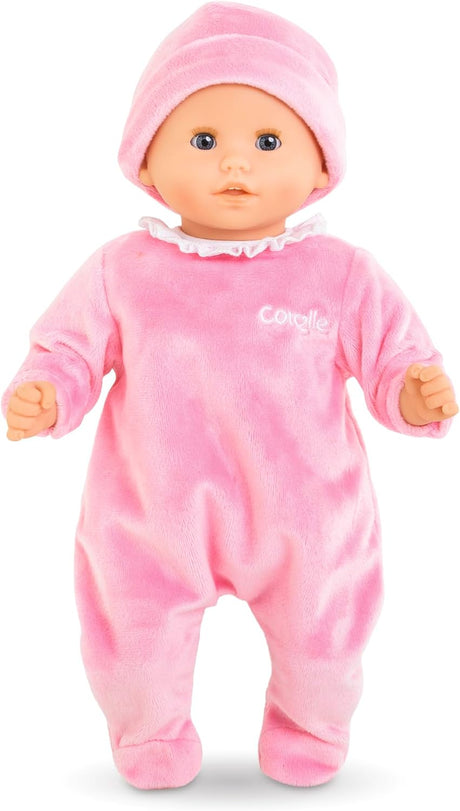 Baby doll wearing soft pink sleeper with white ruffled collar and matching pink hat on a white background