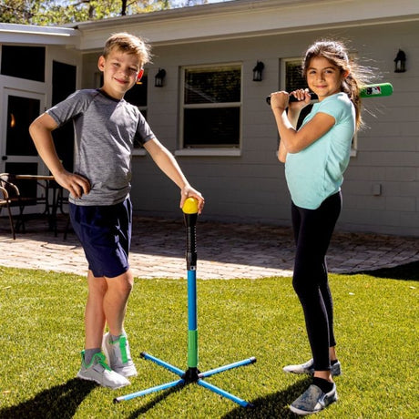 Two kids playing baseball outdoors with the MLB Foam Youth XT Batting Tee Set including tee and bat.