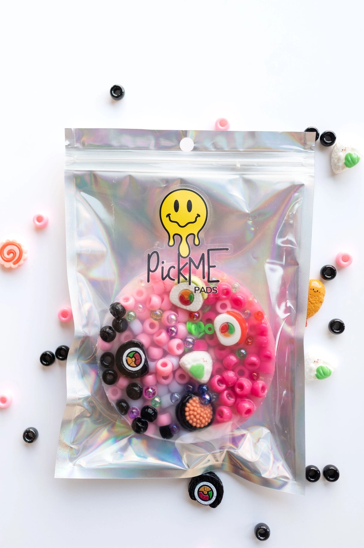 Holographic resealable bag with colorful beads and sushi-themed charms inside PickMe Pad packaging