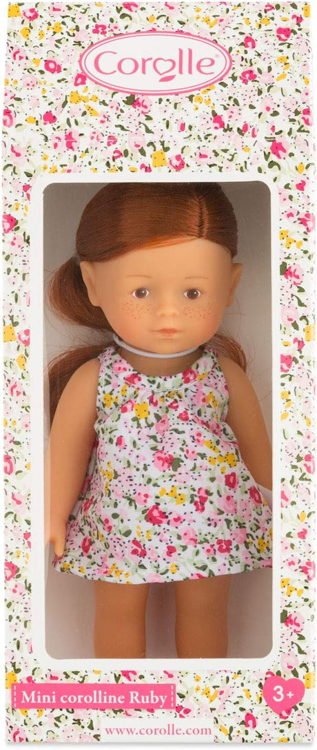 Mini Corolline Ruby doll with red hair, floral dress, and soft vinyl body in colorful Corolle packaging.