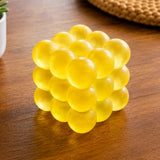 Feelzies Slow Flow Bubble Cube, yellow tactile bubble cube on a wooden table