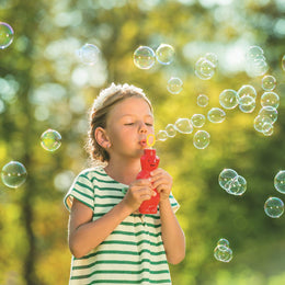 Pustefix Magic Bear red bubble blower held by child blowing bubbles outdoors
