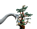 LEGO Brachiosaurus looking at a minifgure of a man standing at the top of a LEGO tree.