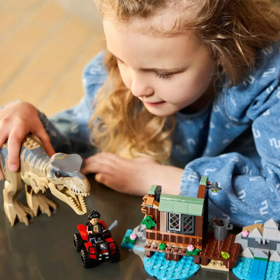 Child playing with LEGO Jurassic T. Rex River Escape set featuring T. rex, minifigures, shed, boat, and ATV.