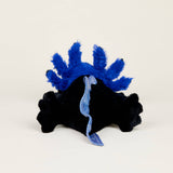 Soft black axolotl plush with bright blue feathery gills and textured tail, perfect for warmth and comfort.