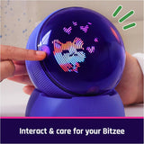 Person touching a glowing Bitzee Hamsterball toy that lights up with animated patterns when interacted with