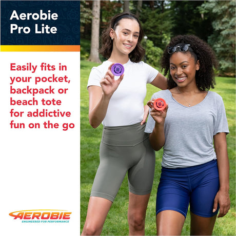 Two women outdoors holding colorful Aerobie Pro Lite miniature throwing discs for fun on the go.