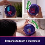 Child interacts with a purple hamster ball toy that responds to touch and movement with colorful digital animations.