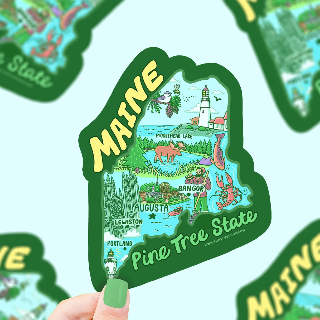 Hand holding colorful Maine map sticker highlighting major cities and landmarks with Pine Tree State text