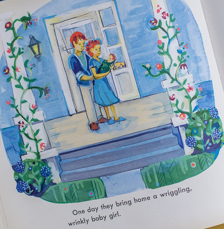 Illustration from The Lantern House showing a family bringing home a baby to their cozy blue front porch.