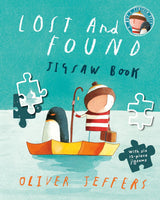 Illustration of a boy and penguin in a boat with jigsaw pieces on a blue background for a children’s puzzle book.