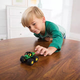 Young boy playing with a John Deere Mini Mudder toy vehicle with large bouncy tires on a wooden table