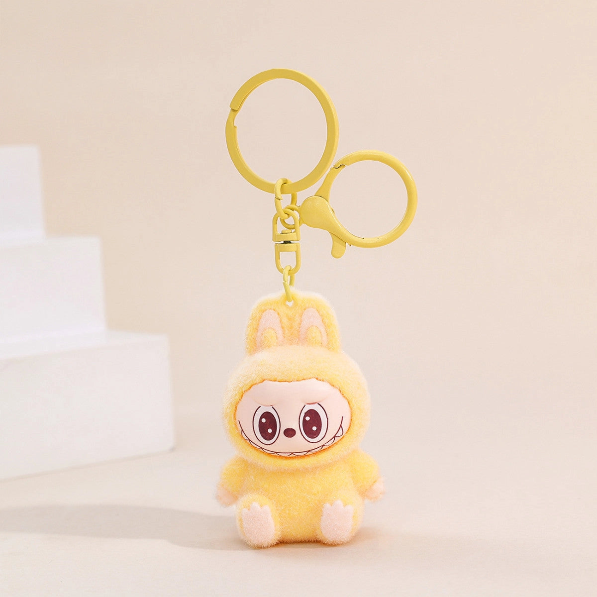 Labubu Flocking Keychain with fuzzy texture and playful smile attached to yellow keyring accessory.