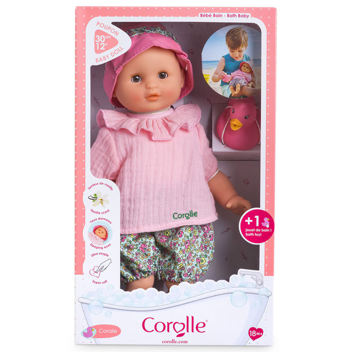 Coralie baby doll dressed in pink top and floral bloomers with pink hat in bath-themed packaging with rubber duck toy