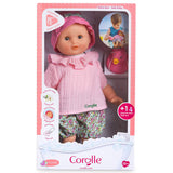 Coralie baby doll dressed in pink top and floral bloomers with pink hat in bath-themed packaging with rubber duck toy