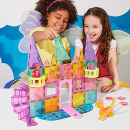Two children playing with colorful Magnatiles Castle DLX set featuring drawbridge, spiral staircase, and dragon figure.