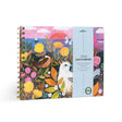 Spiral-bound artist sketchbook with colorful floral and bird illustrations on the cover and a pale blue label band