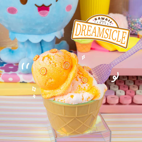 Dreamsicle Ice Cream Slime shaped like orange and white ice cream with citrus slice sprinkles on a plastic spoon.