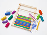 Portable hardwood lap loom with colorful woven fabric and vibrant yarn spools on white background