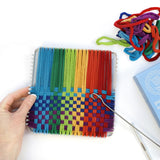 Hand weaving colorful cotton loops on a sturdy metal potholder loom with weaving hooks and extra loops nearby