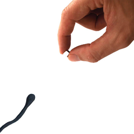 Hand holding magnet near black Magnetic Glux Putty showcasing its magnetic properties and sensory play features.