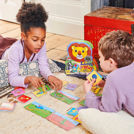Children playing the cooperative card game Lion in My Way with colorful path and tool cards on a rug.