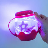 Mini Sensory Jar | Pink glowing sensory jar with star shaped pieces held in a hand