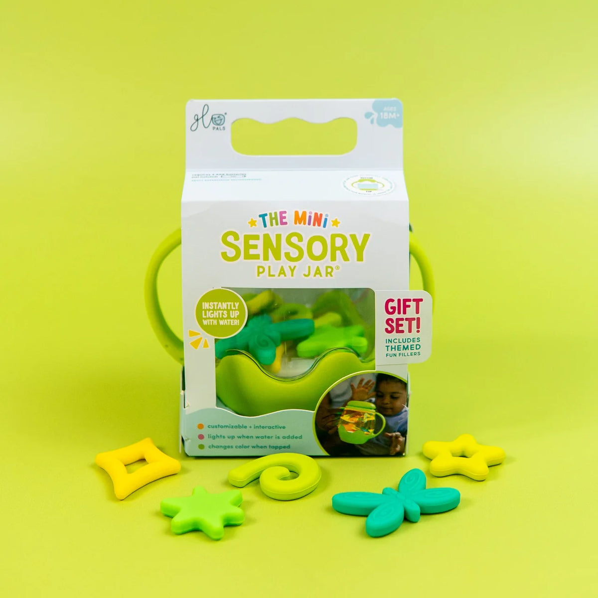 Mini Sensory Jar | Green packaging with green sensory jar and colorful fidget pieces on a bright green background
