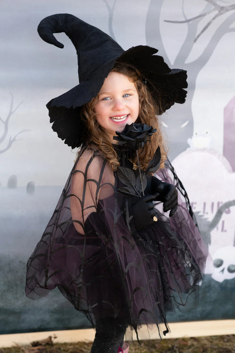 Child wearing Spider Witch Tutu & Cape Size 5-6 with spider web cape and black tutu skirt smiling outdoors.