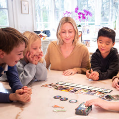 Family playing the "Feelin' Cute" card game around a table, enjoying a fun and friendly game time together.