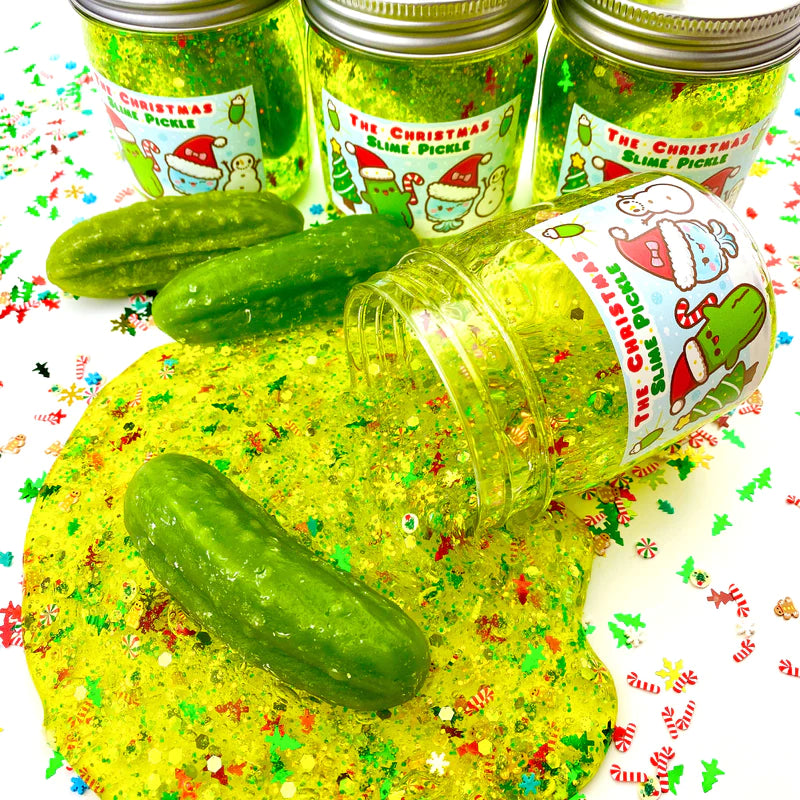 The Christmas Pickle Clear Slime with festive glitter, pickles, and holiday charm spilling from a jar.