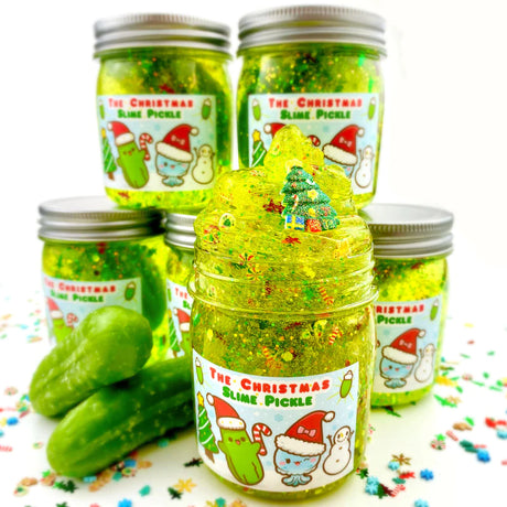 The Christmas Pickle Clear Slime jar with bright green sparkly slime, holiday glitter, pickles, and Christmas charm inside.