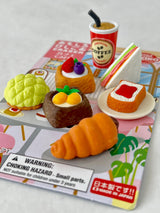Miniature Japanese eraser set featuring puzzle piece bakery items and a coffee cup on colorful packaging