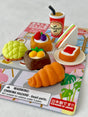 Miniature Japanese eraser set featuring puzzle piece bakery items and a coffee cup on colorful packaging