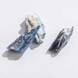Rock | Rough Blue Kyanite showing natural textured surfaces with blue and white mineral layers on a white background