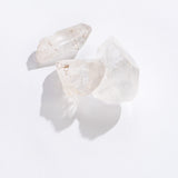 Three clear quartz point crystals with natural imperfections on a white background, Rock | Clear Quartz Point.