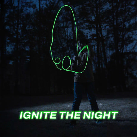 Person playing with a glowing green ZipString Luma glow-in-the-dark toy string outdoors at night in a forested area