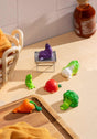 Lazy Veggies Blind Box featuring colorful miniature vegetable figurines arranged on a wooden table