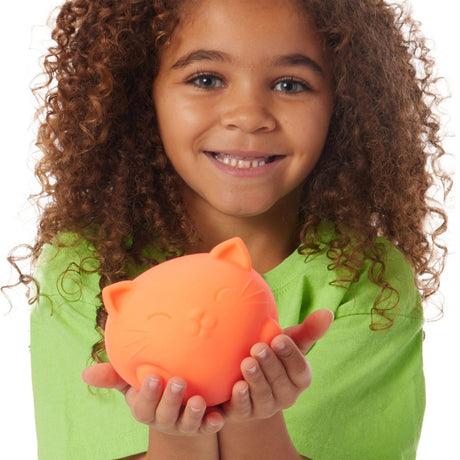 Child holding an orange NeeDoh Super Cool Cat stress ball toy for squeezing and fidgeting fun.