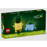 Box of Botanicals Happy Plants LEGO set featuring a yellow dracaena and blue pilea plant pots with faces.
