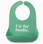 Green silicone bib with adjustable snaps and pocket featuring the phrase "f is for foodie" in white text