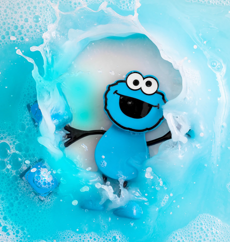 Glo Pals Cookie Monster Character glowing in blue liquid with water splashes around the cheerful figure.