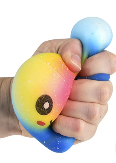 Hand squeezing colorful Squish & Stretch Rainbow Octopus stress toy with yellow, pink, and blue hues.