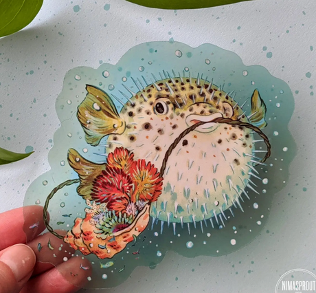 Pufferfish Sticker showing a detailed pufferfish with coral and seashell on a clear blue vinyl background.
